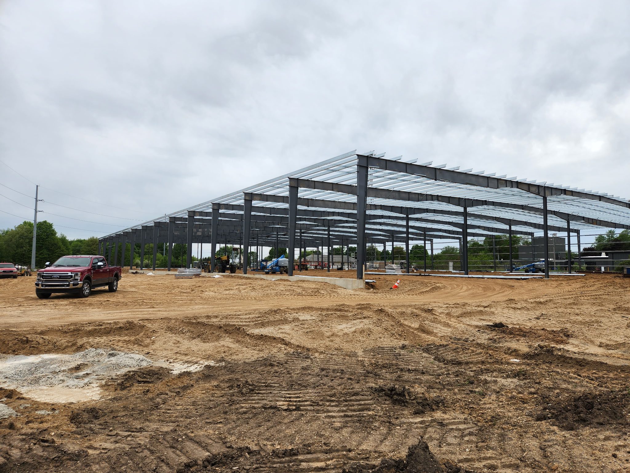 Steel framework of a building under construction on a cloudy day.