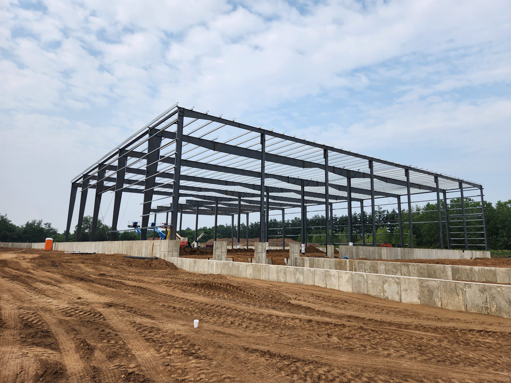 Steel framework of a building under construction on a clear day.