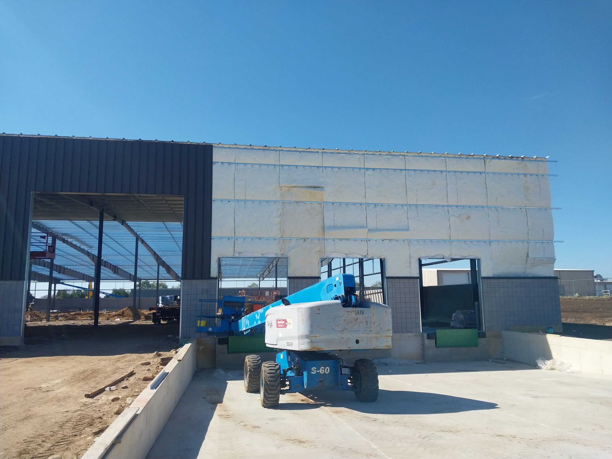 Construction site with machinery under a clear blue sky.