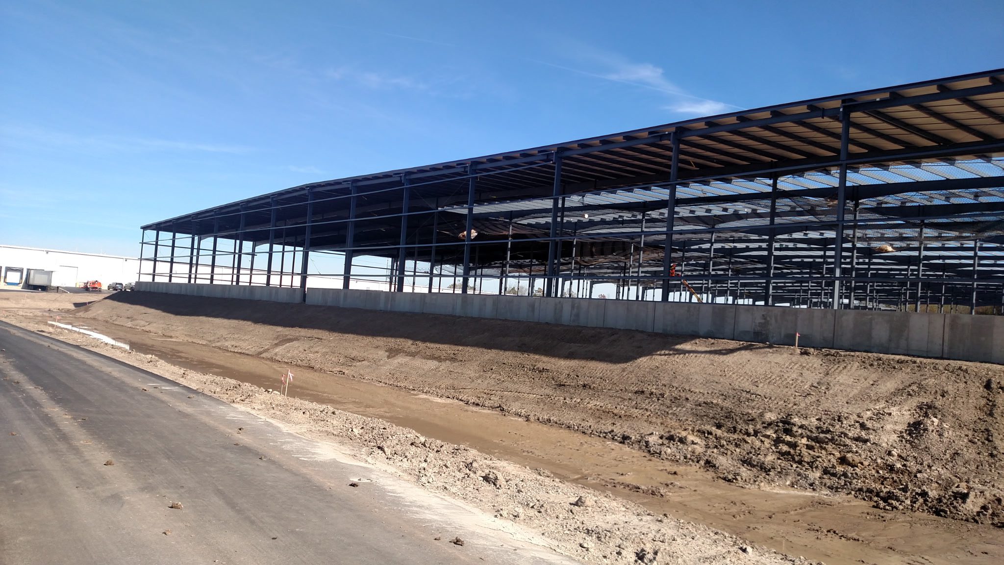 Steel framework of a large building under construction on a clear day.