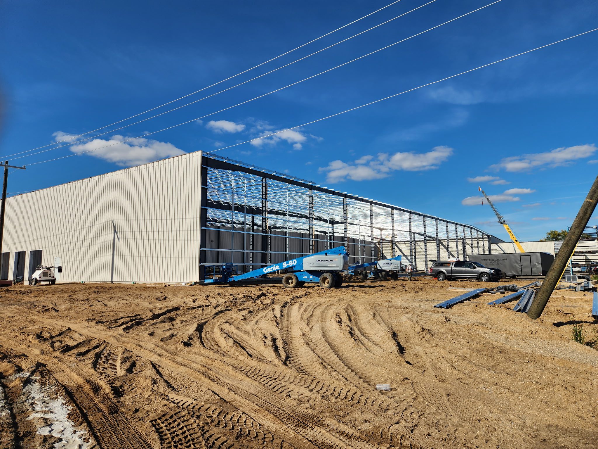 Construction site of a large industrial building under a blue sky.