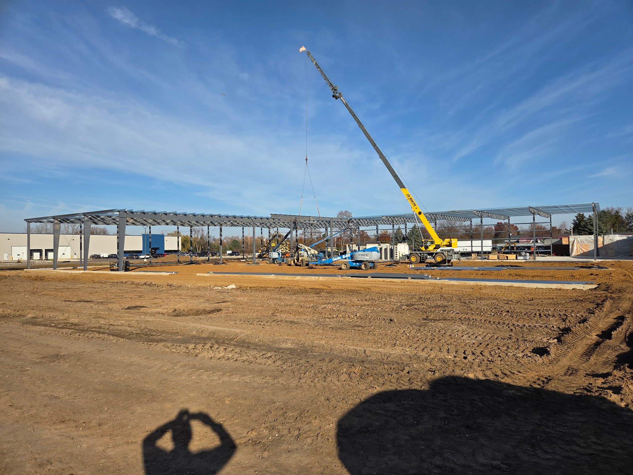 Construction site with a crane under a clear blue sky.