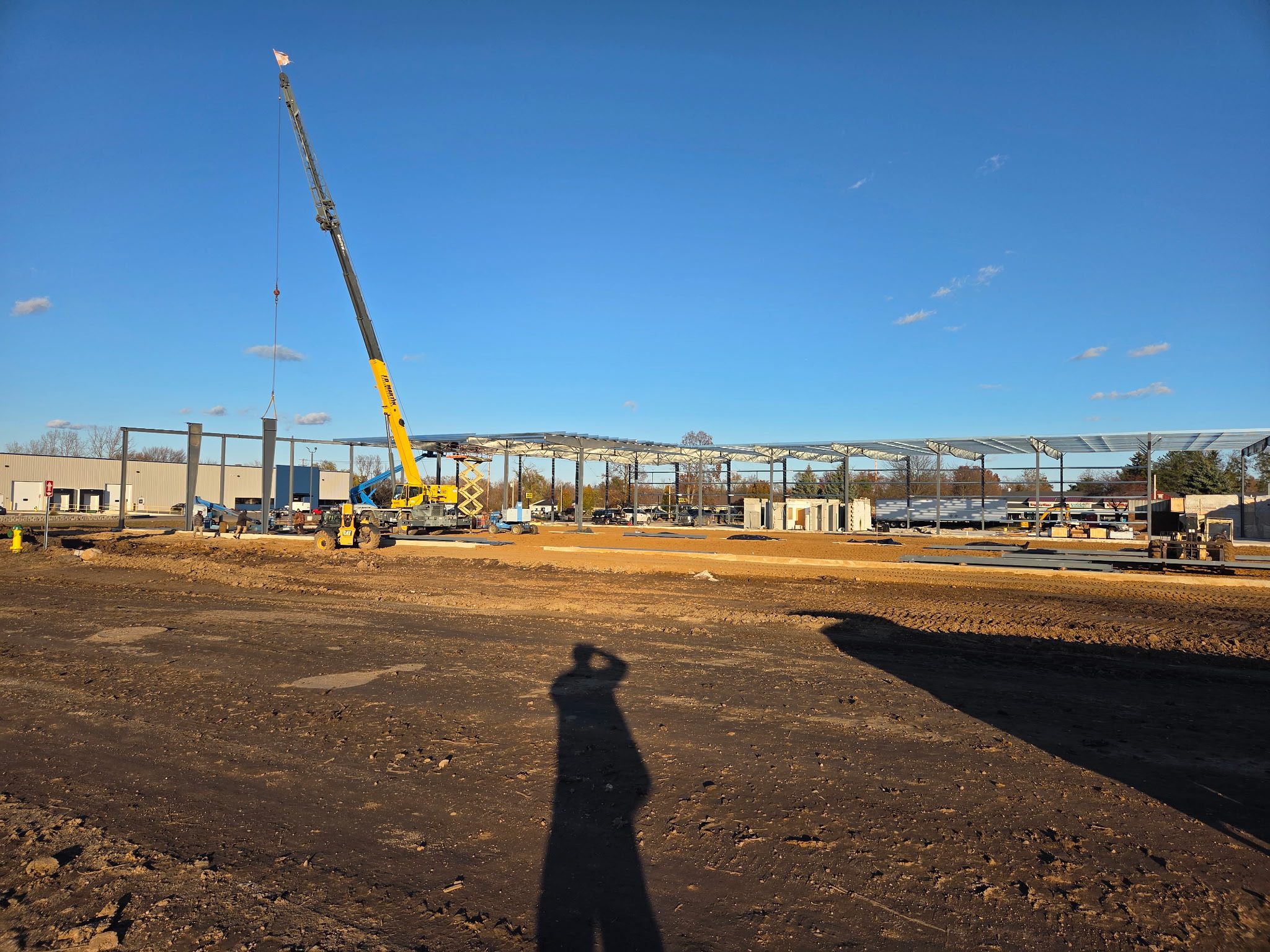 Construction site with a crane lifting materials under a clear blue sky.