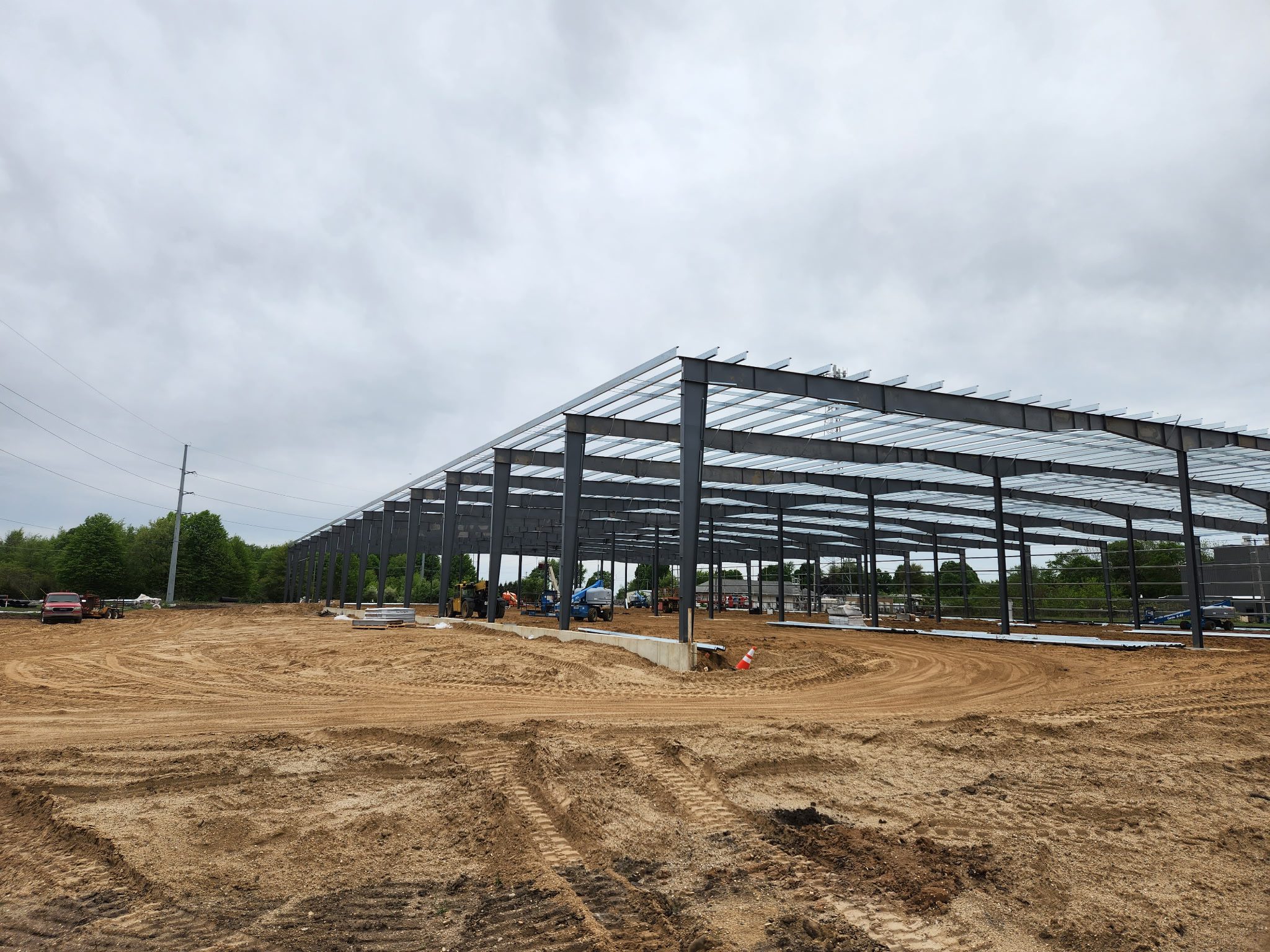Steel framework of a large building under construction on a clear day.