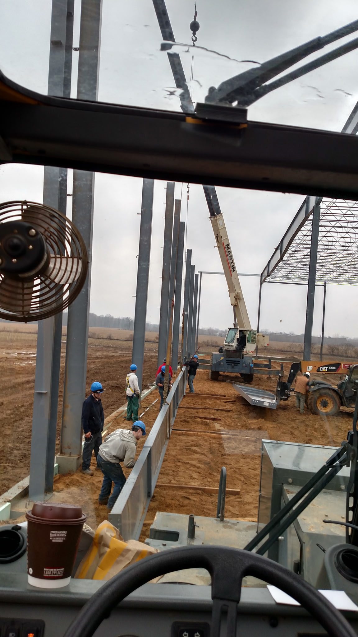 Construction workers installing steel frames at a building site.