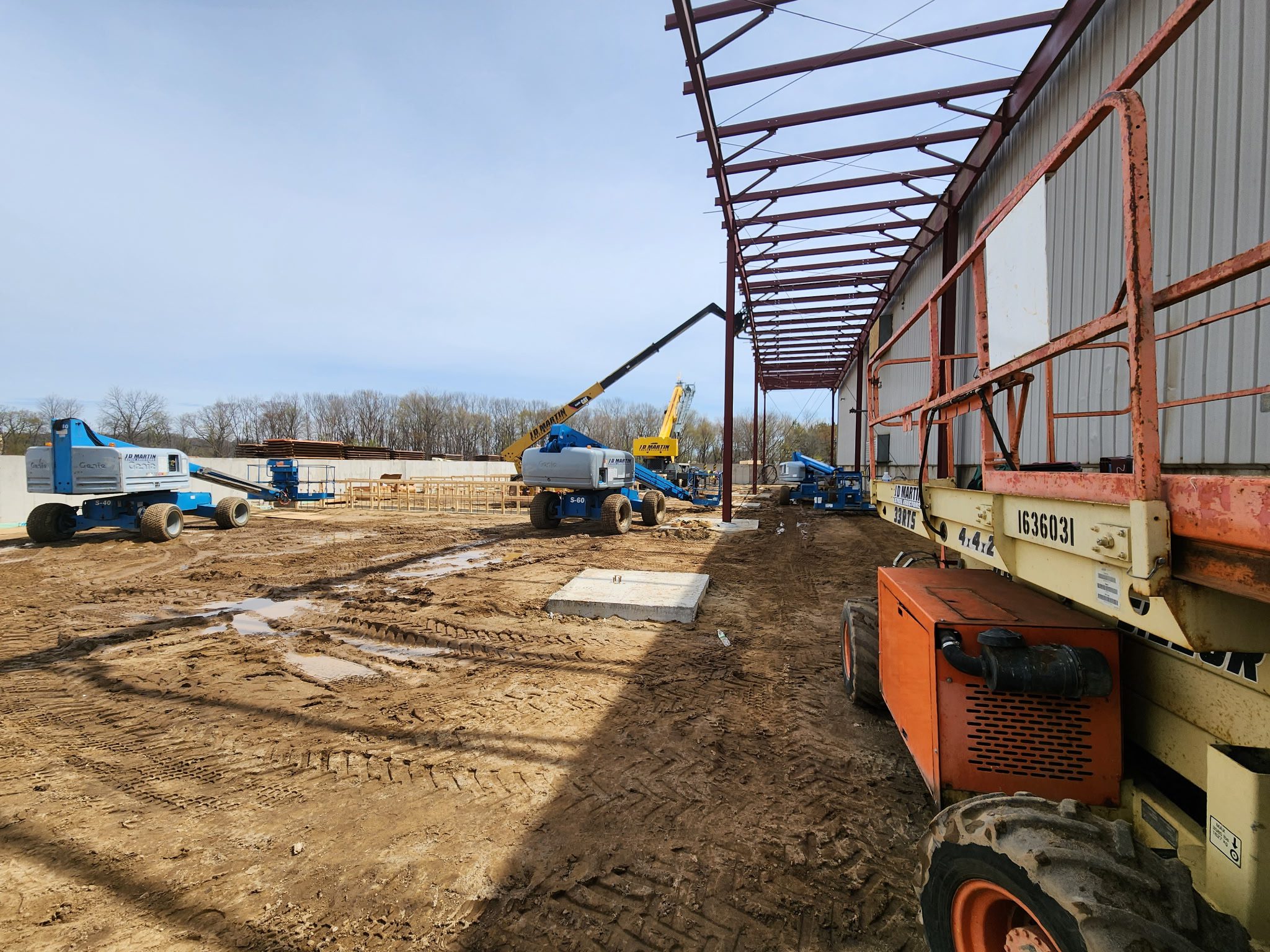 Construction site with cranes and steel framework being erected.