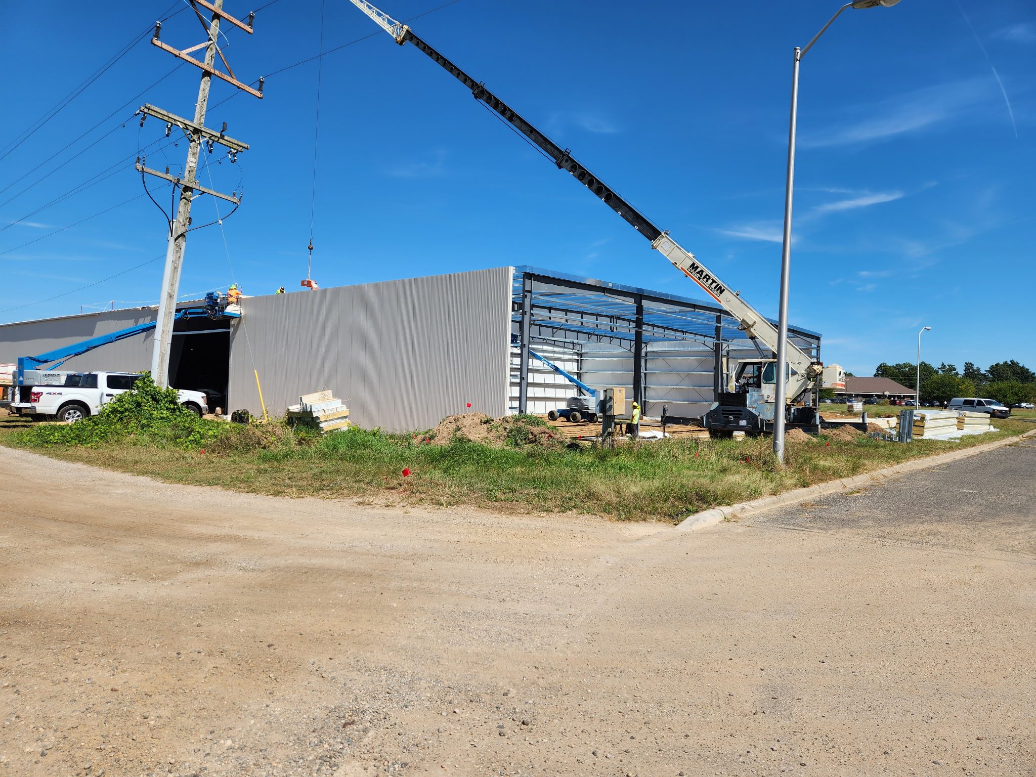 Construction site with a crane lifting materials onto a building frame.