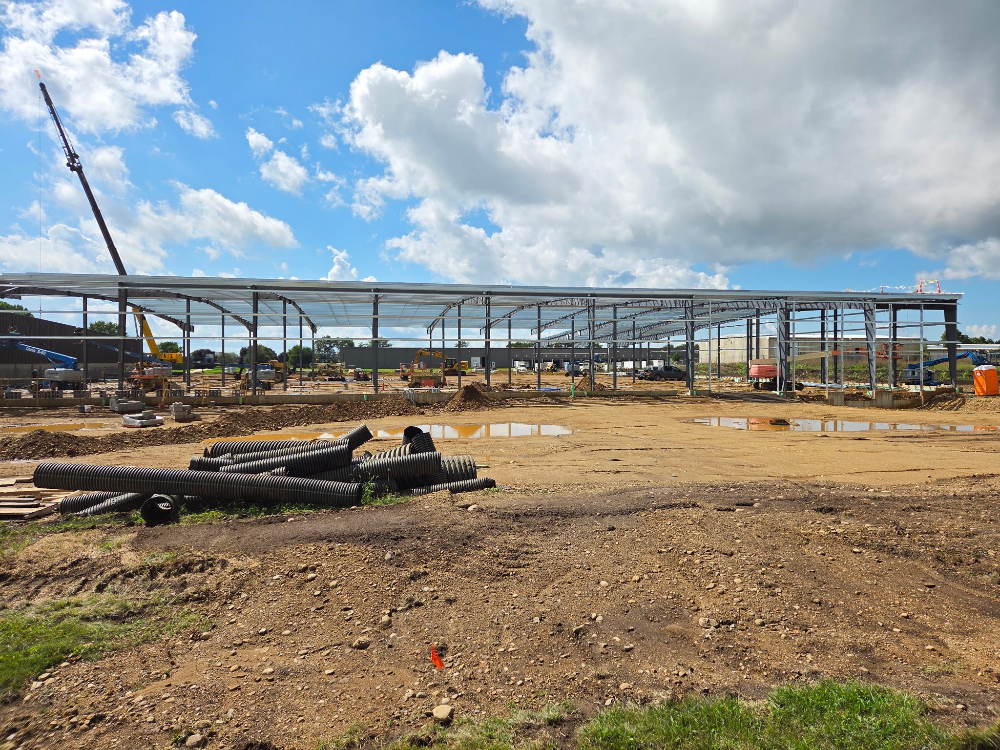 Construction site with steel framework under a blue sky.