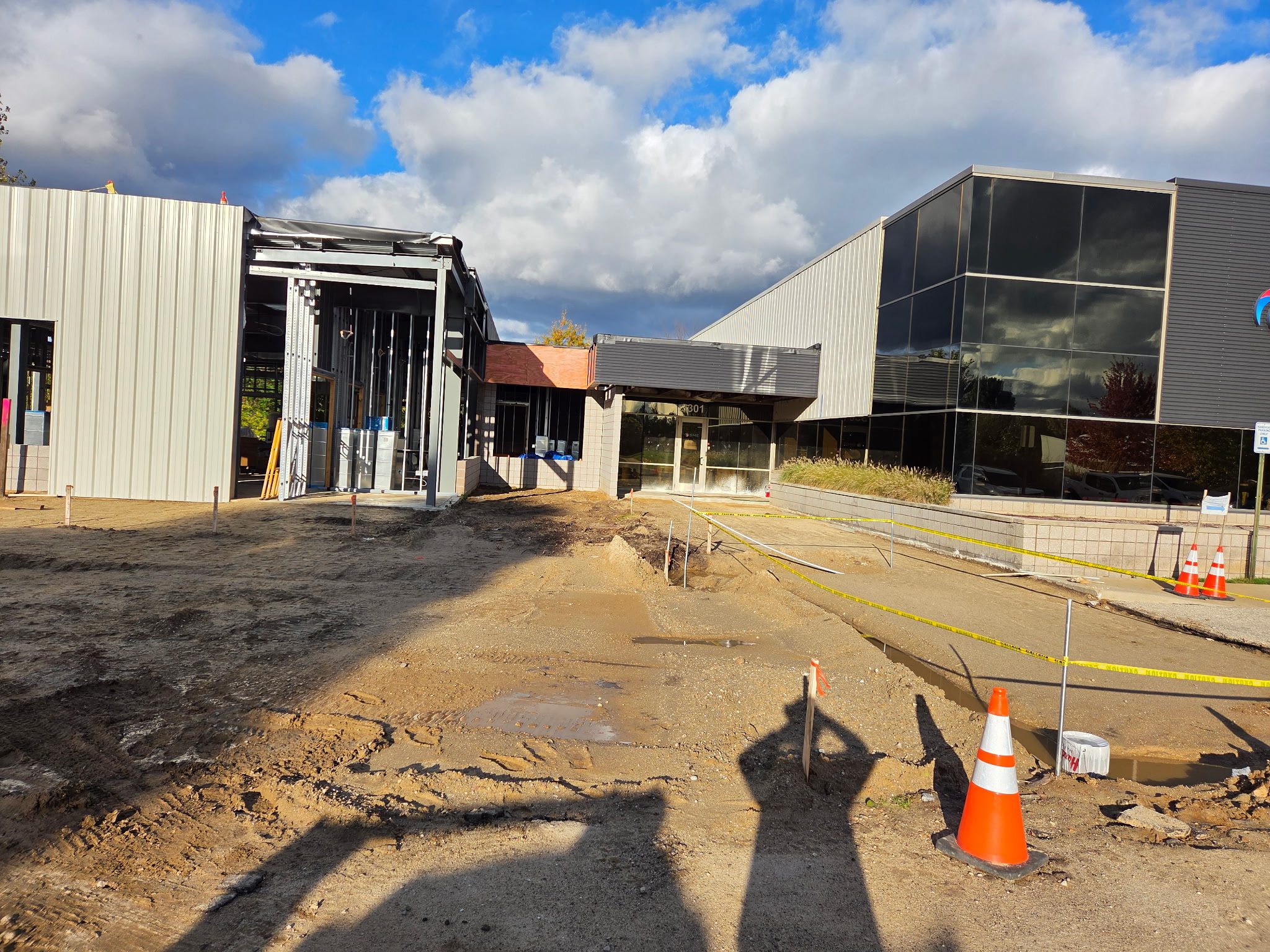 Construction site with modern buildings under a partly cloudy sky.