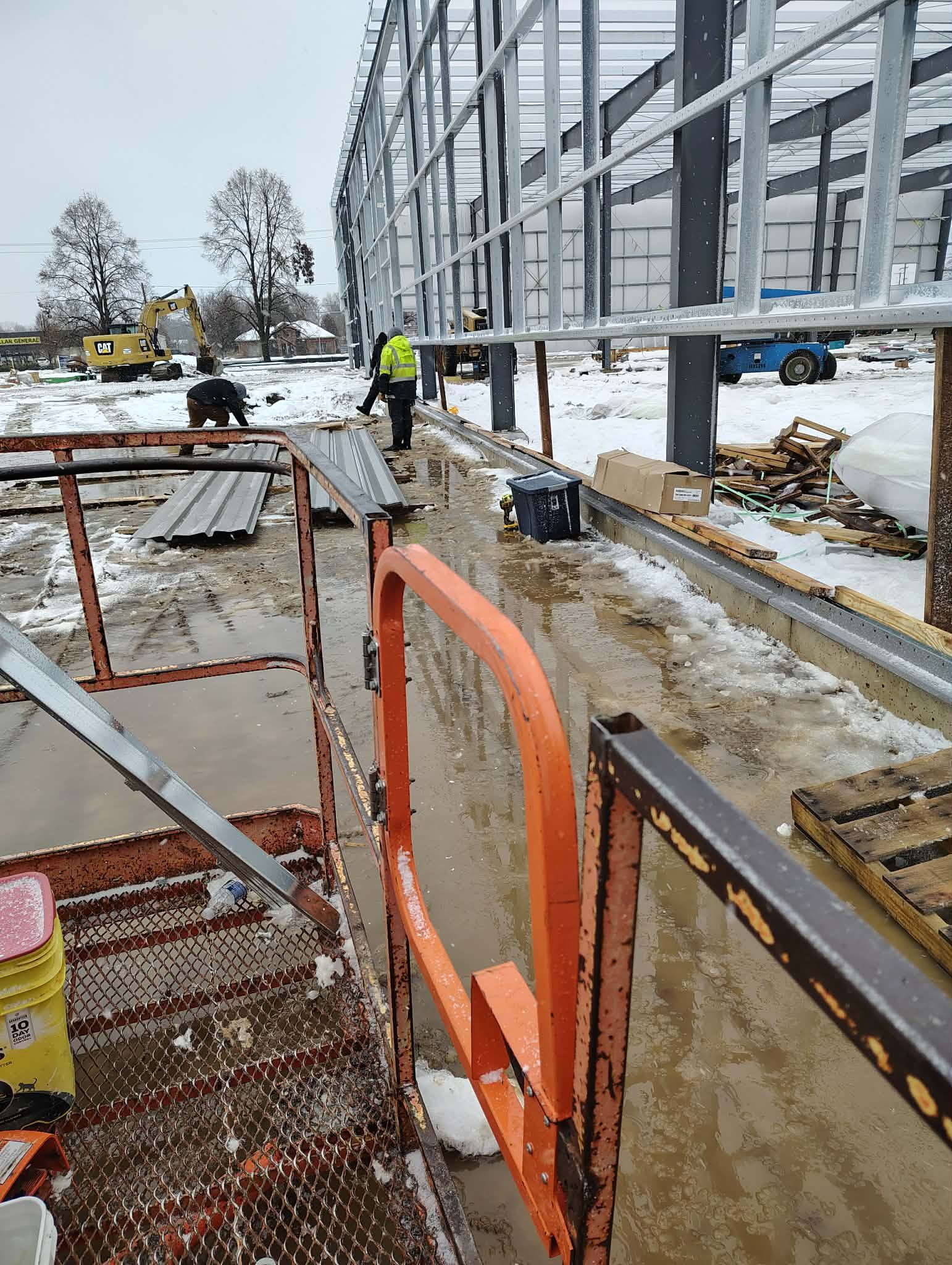 Construction workers building a concrete structure on a cold day.