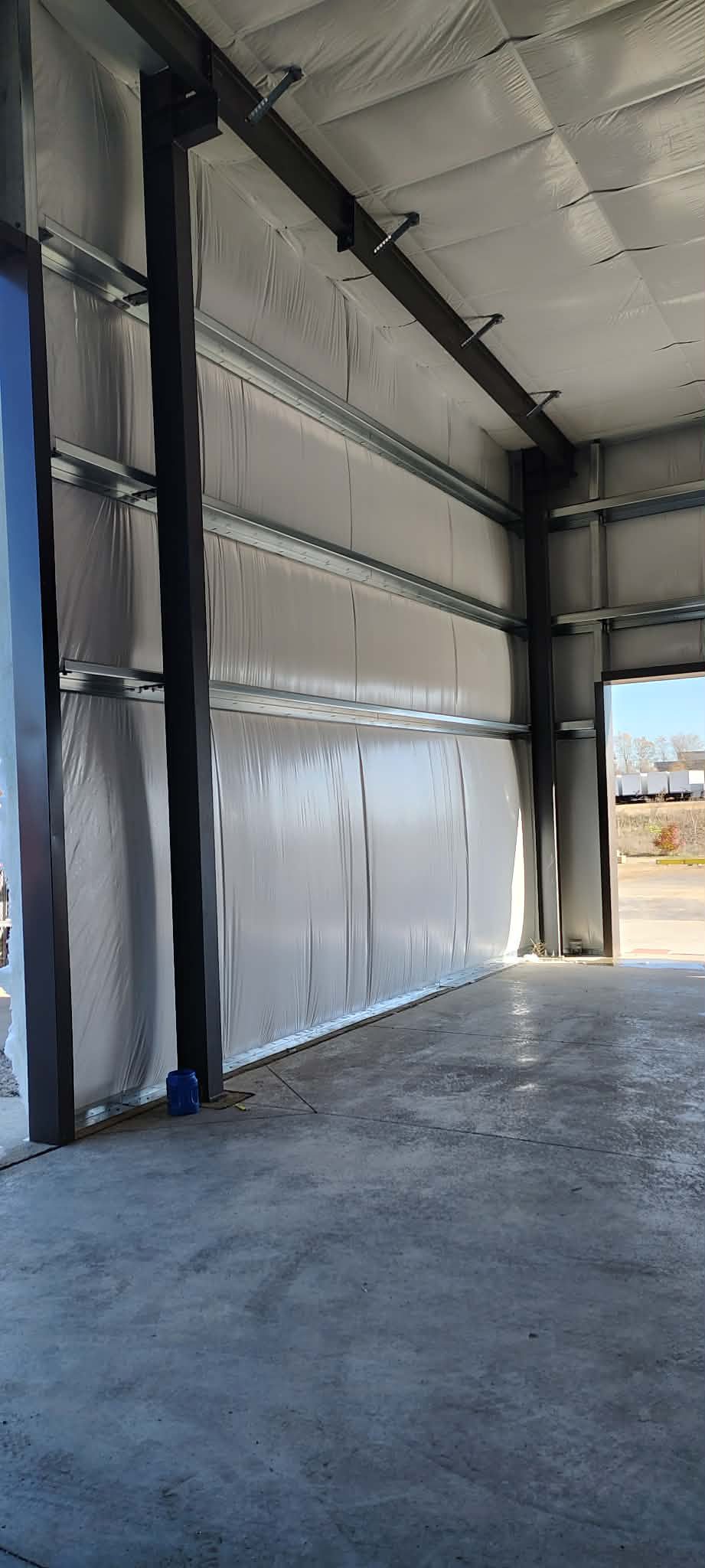 Interior view of a warehouse door with insulation and open space.