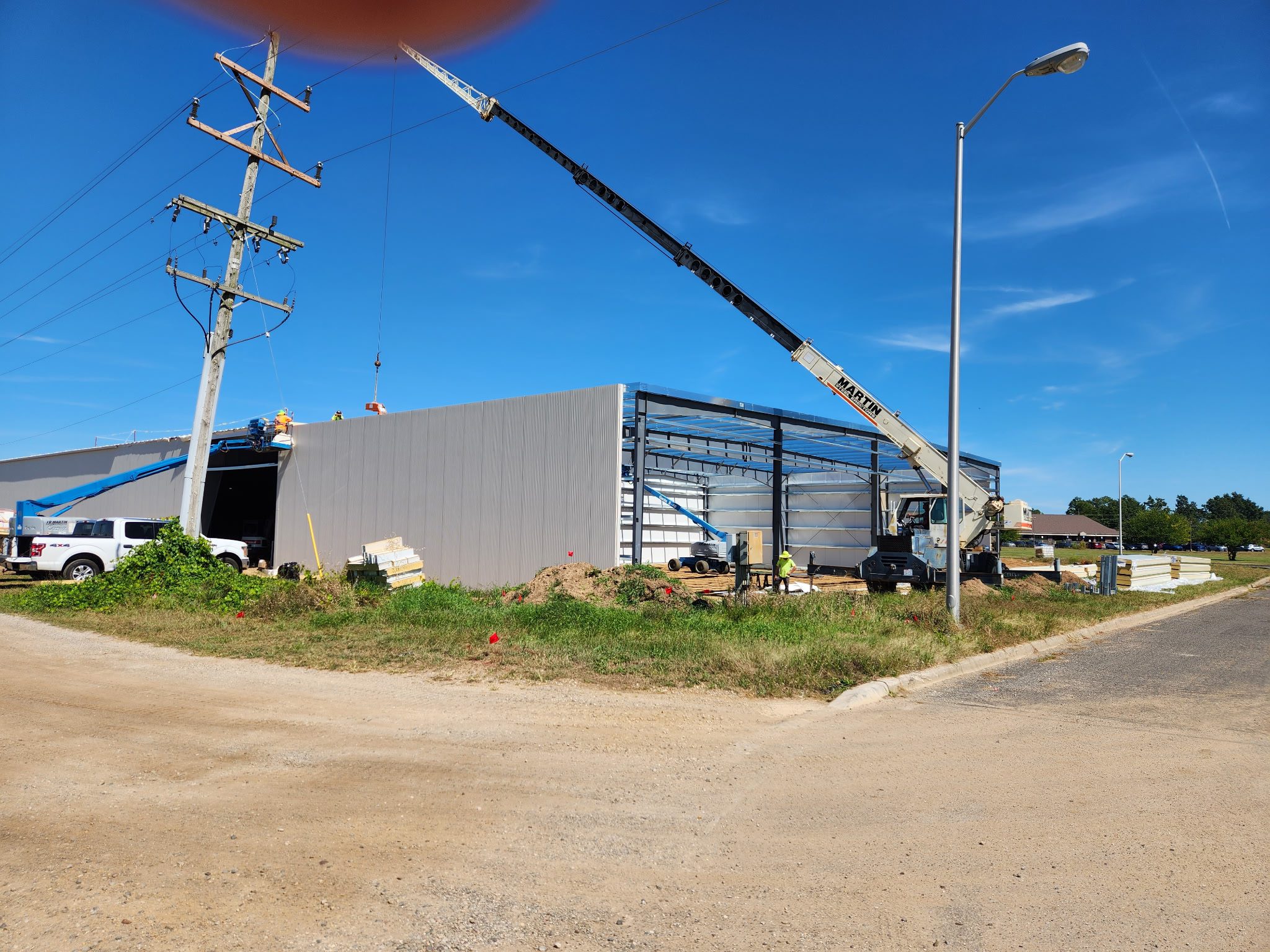 Construction crane working on a building frame under clear blue sky.