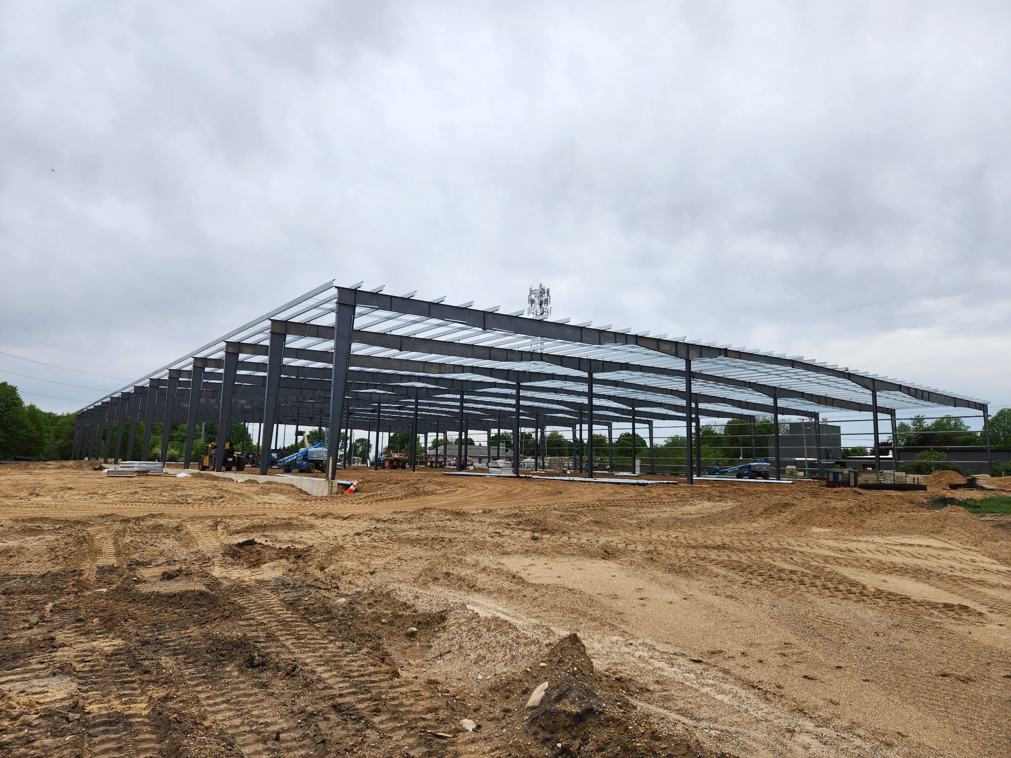 Steel framework of a building under construction on a cloudy day.