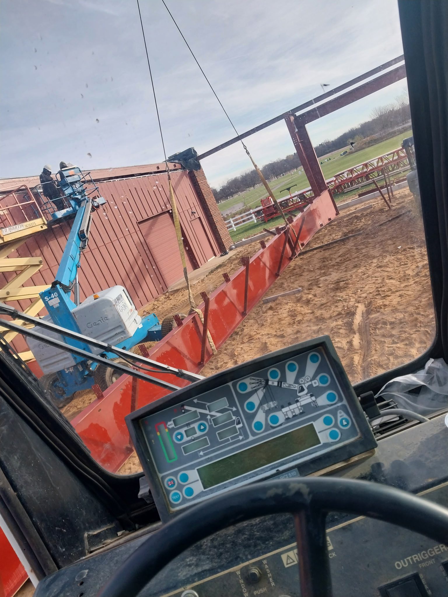 View from a tractor cabin showing a plow and farm field.