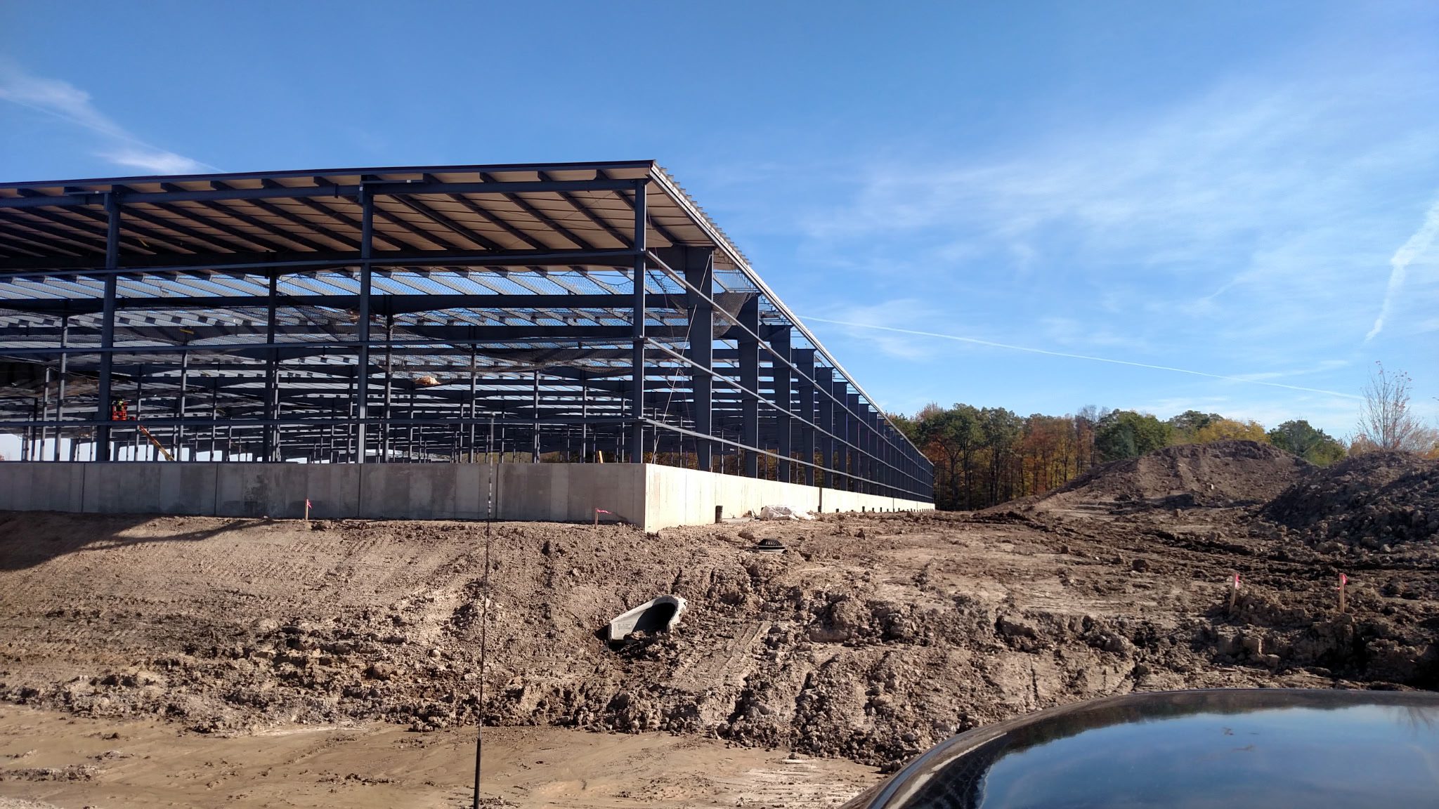 Steel framework of a large building under construction on a clear day.