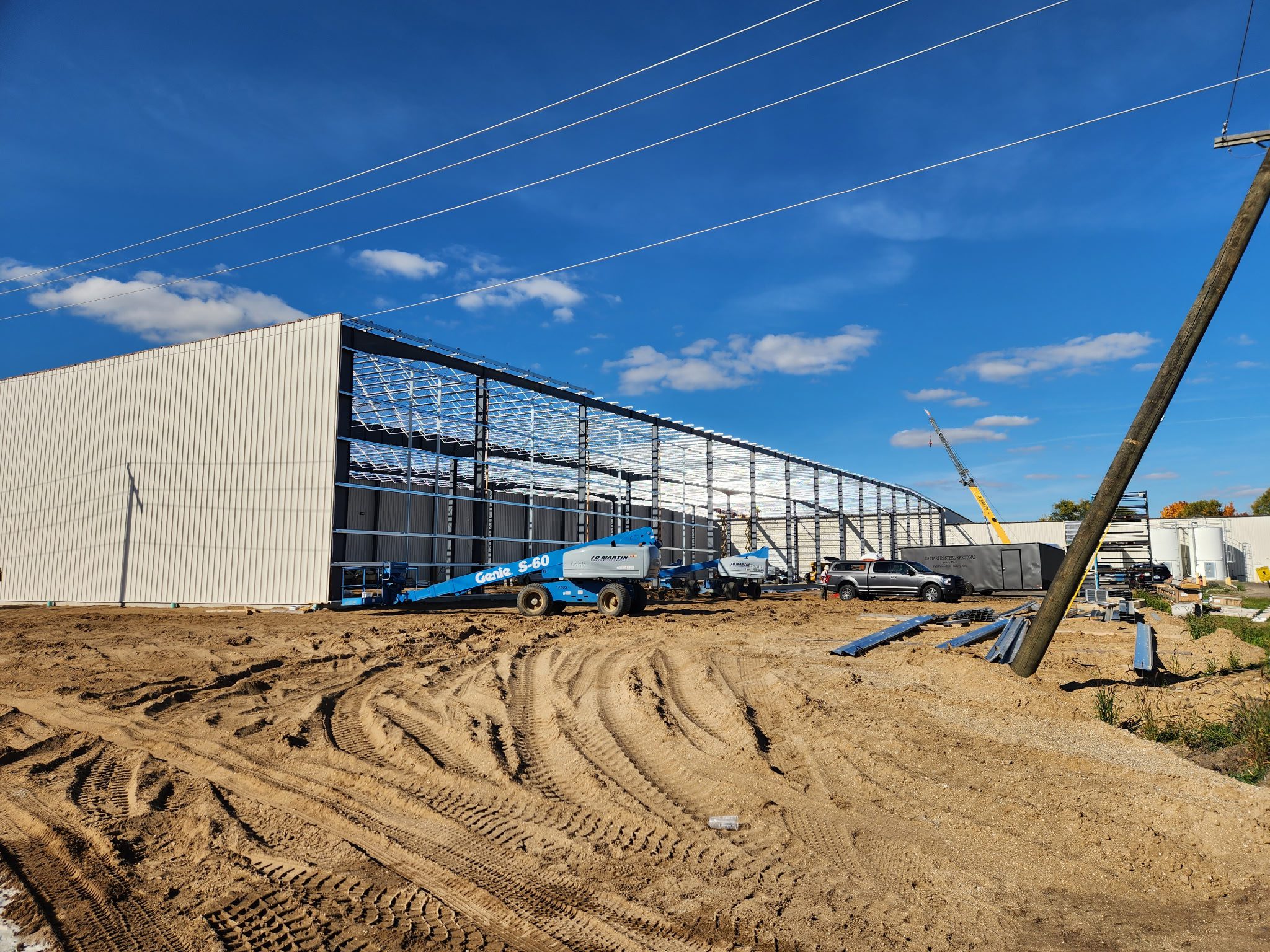 Construction site of a large industrial building under a blue sky.