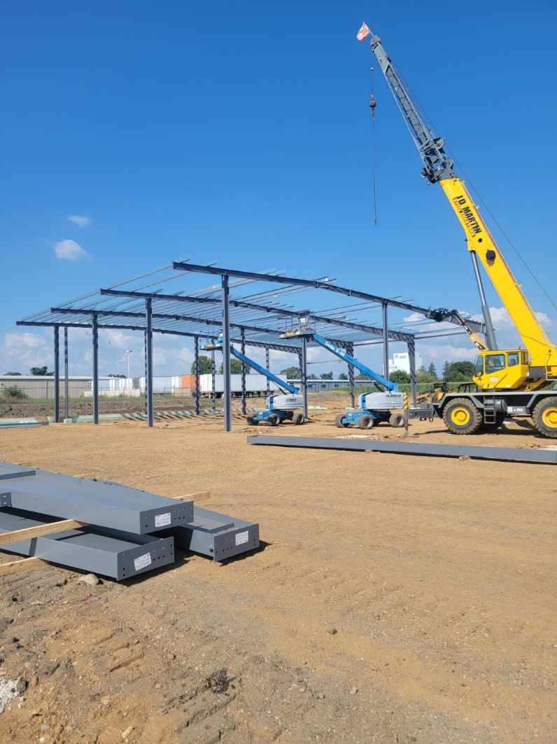 Construction site with steel frame structure and crane.